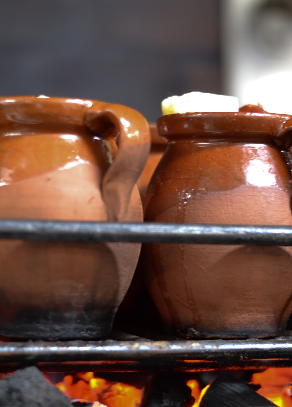 Pucheros de barro con cocido madrileño cociéndose sobre carbón de encina en Taberna La Bola